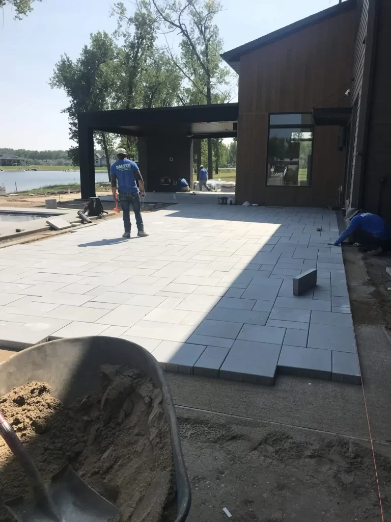 Workers laying bricks on a patio project