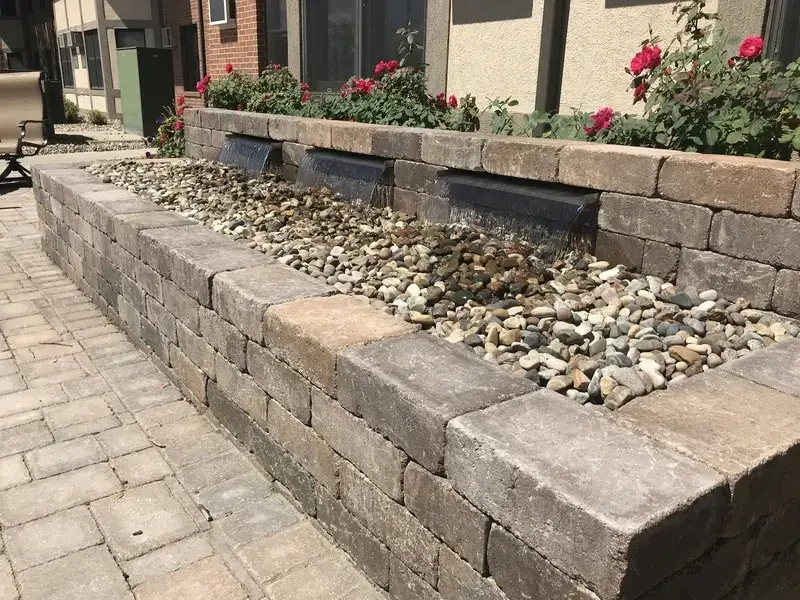 A photo of a concrete retaining wall with a waterfall